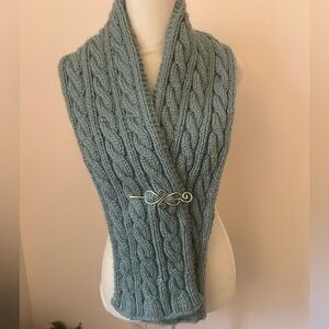 Cozy Cable Knit Scarf knitted in a muted ocean blue. Celtic pin included.